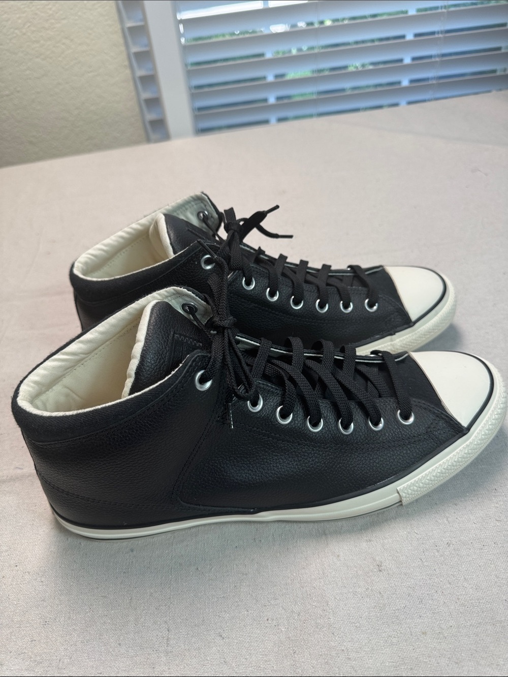 Converse All Star Black Leather White Low-Top Sneaker with Black Details.